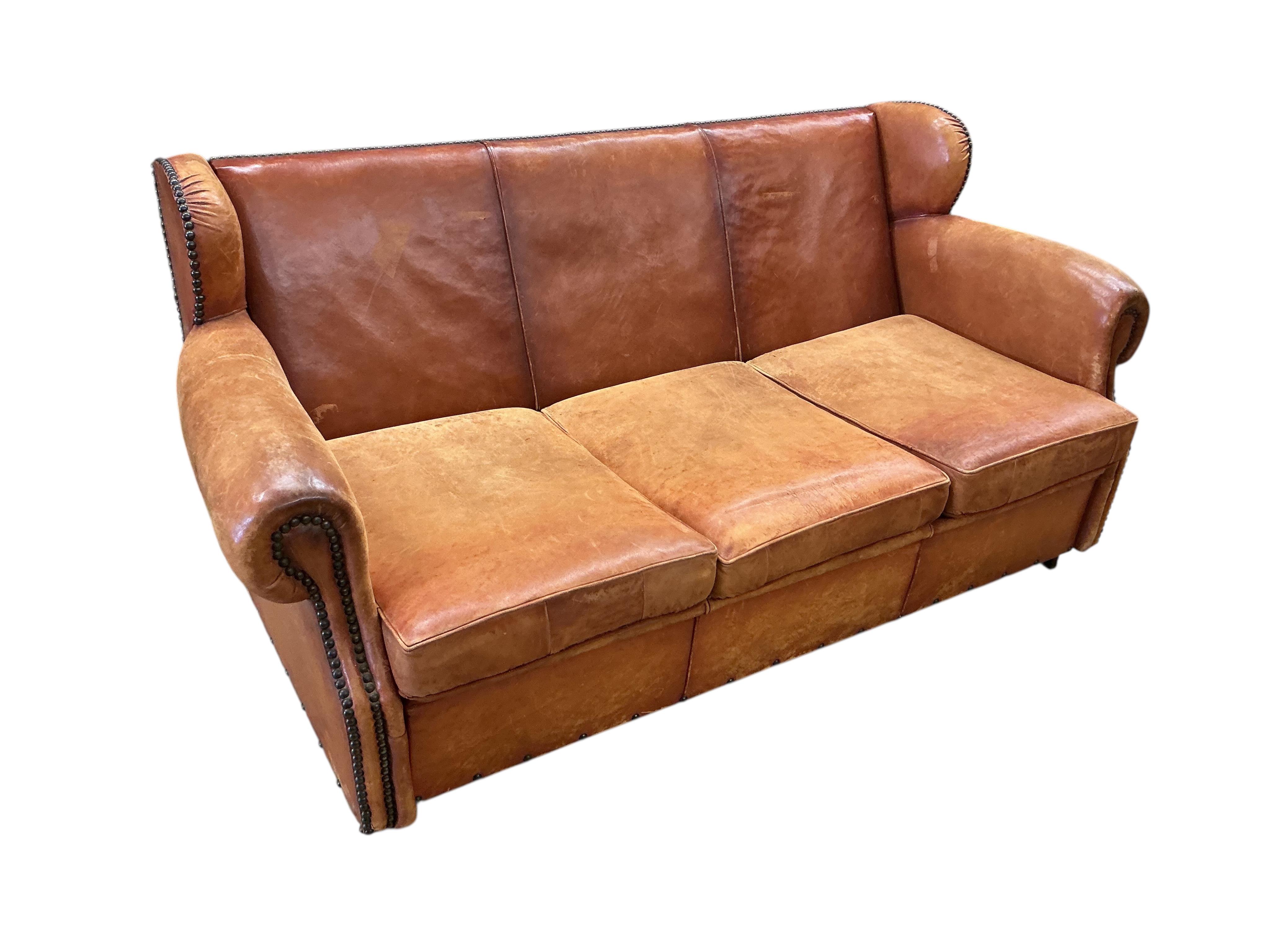 A brass studded tan leather three seater sofa bed, width 180cm, depth 90cm, height 86cm